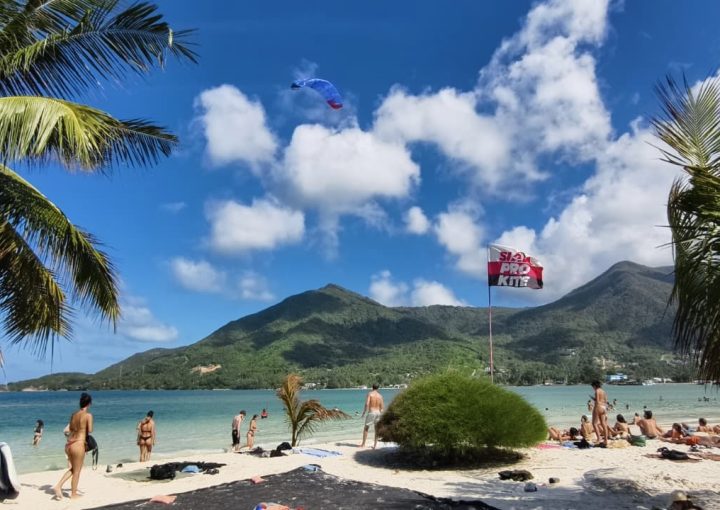 Panoramic view of Malibu Beach peninsula tip in Chaloklum Koh Phangan with kitesurf beginner lesson, tropical scenery and mountains.
