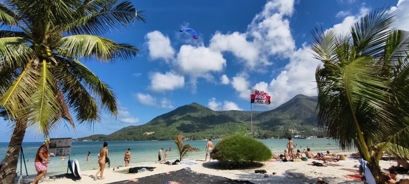 Panoramic view of Malibu Beach peninsula tip in Chaloklum Koh Phangan with kitesurf beginner lesson, tropical scenery and mountains.